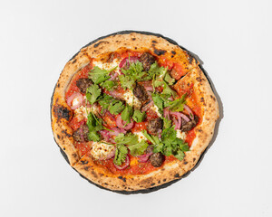 Homemade pizza with meatballs and greens closeup top view isolated on white background