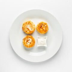 Cheese pancakes top view with sour cream on white plate  on white background isolated