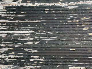 Bleached white wood with peeling black paint. Rough, grunge background texture.