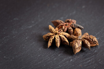 closeup of star anise on a black background, photographed from the top