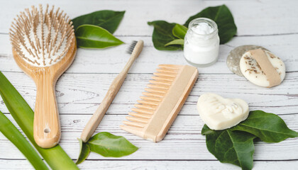 Fototapeta na wymiar Eco friendly bathroom set of bamboo hairbrush, comb and toothbrush together with organic soaps and lotions
