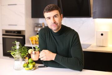 Man preparing a Moscow mule cocktail in copper cup 