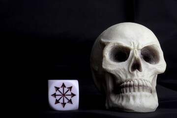 human skull miniature with an icon on a dice