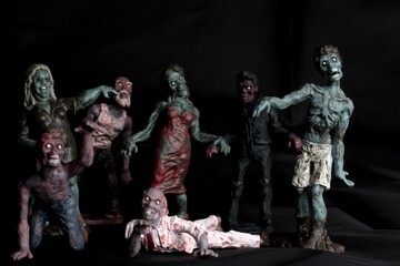 close up of a zombie doll against a black background