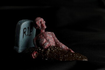 close up of a zombie doll against a black background
