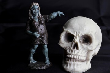 close up of a zombie doll against a black background