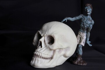 close up of a zombie doll against a black background