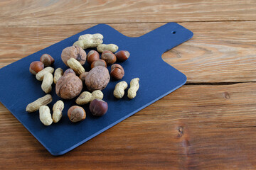 Variety nuts, peanuts, walnuts and hazelnuts wooden background.