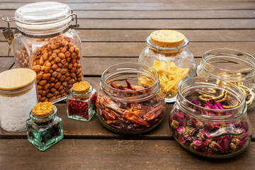 glass jars filled with assorted seasonings, rice, soup paste and salt flakes, dried chillies, tea roses and more