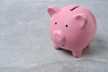 Pink piggy bank light concrete background.