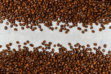 Naklejka premium Roasted coffee beans background light concrete texture.