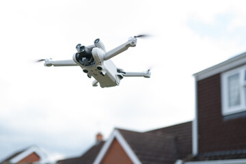 Consumer high-tech drone showing its gimbal camera while just about to make height for an aerial survey.