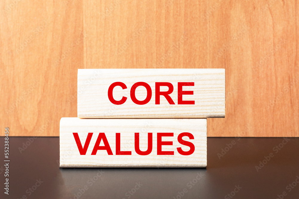 Poster two wooden blocks with the text core values on a light wooden background