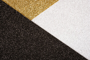 Festive abstract geometric glitter background in golden, black and silver colours with copy space. Minimal fashionable style backdrop. Luxury background