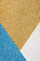 Festive glitter background in golden, blue and silver colours with copy space. Minimal fashionable style backdrop. Luxury background. Vertical image