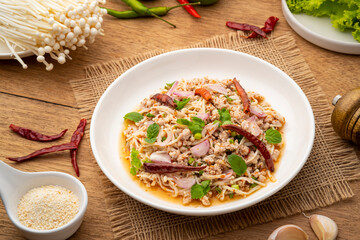 Thai spicy salad with Golden Needle Mushroom and minced Pork in white plate
