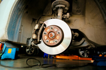 Front disc brakes and calipers without the car wheels in the auto repair garage