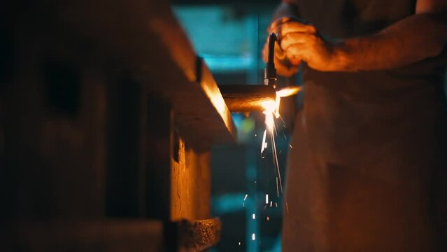 A male locksmith cuts metal with an oxy-fuel torch in a metal cutting workshop