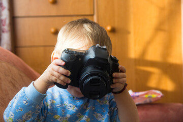 A small child is playing with a camera close-up.