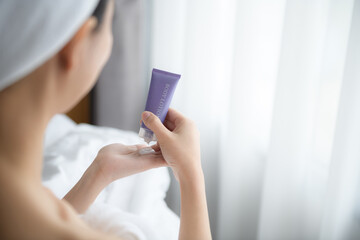 Close up of women applying body lotion cream on hand.