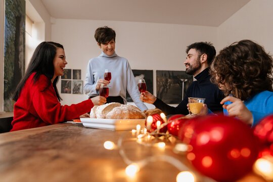 Happy Multigenerational Family Having Christmas Dinner And Drinking Wine At Home