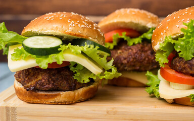 Burgers with beef meat, cheese and lettuce, served on cutting board