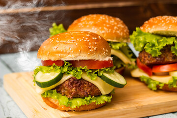 Tasty burgers with steam smoke