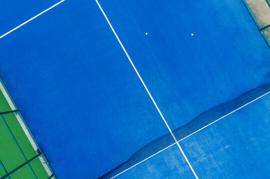 aerial view of a blue paddle tennis court with balls © Vic