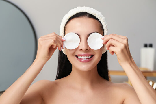 Young Woman Using Cotton Pads With Micellar Water Indoors