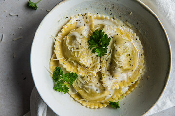 Mezzelune filled with parmesan and asparagus with creamy sauce and grated parmesan.