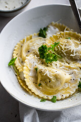 Mezzelune filled with parmesan and asparagus with creamy sauce and grated parmesan.