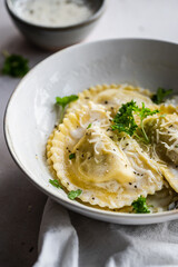 Mezzelune filled with parmesan and asparagus with creamy sauce and grated parmesan.