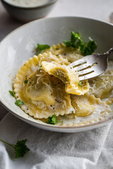 Mezzelune filled with parmesan and asparagus with creamy sauce and grated parmesan.