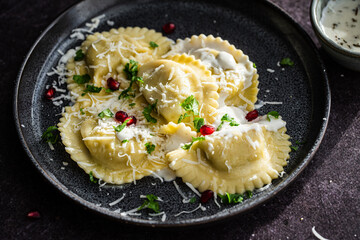 Mezzelune filled with parmesan and asparagus with creamy sauce decorated with parsley and...
