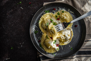 Mezzelune filled with parmesan and asparagus with creamy sauce. - obrazy, fototapety, plakaty