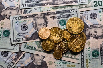 Golden coins on a background of 20 dollar bills