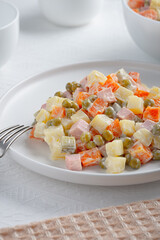 Russian traditional salad Olivier with vegetables and meat