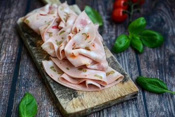 Slices Of  Traditional Italian antipasti mortadella on a wooden  cutting board