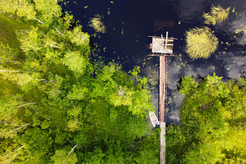 Lake for fishing with wooden pier, aerial view. Mole (pier) on the lake. Aerial landscape, summer lake shore with dock for boats