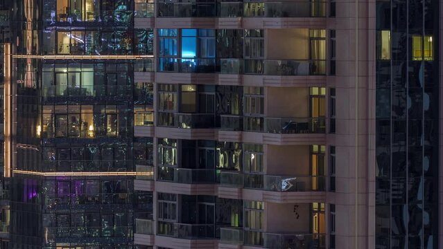 Windows of apartment buildings at night timelapse, the light from the windows of houses. Evening landscape of the city with glowing rooms