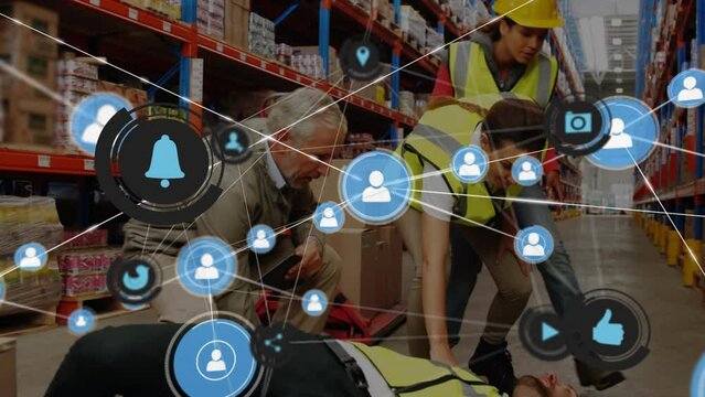 Animation of connected icons over coworkers helping unconscious man lying on floor in warehouse