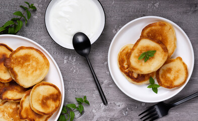 Pancakes with sour cream on a gray wooden table