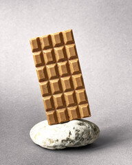 Bar of white chocolate on stone gray background. Side view. Place for text