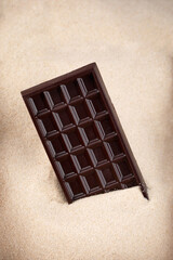 bar of dark chocolate lies in sugar, chocolate abuse and addiction concept, body and dental care