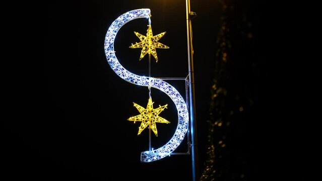 Illumination de No&euml;l scintillante sur un lampadaire la nuit repr&eacute;sentant deux &eacute;toiles