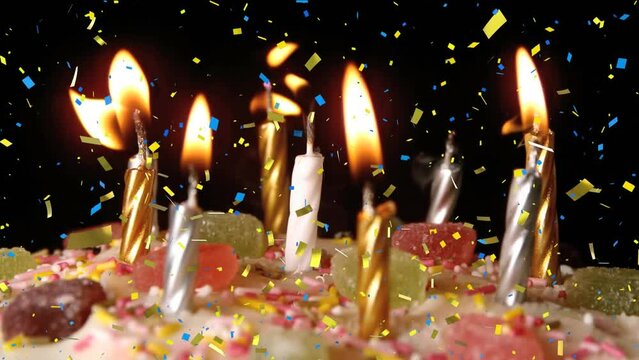 Animation of confetti falling over birthday cake with candles on black background