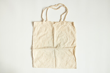 A fabric beige bag lies on a white background, a grocery bag, flat lay