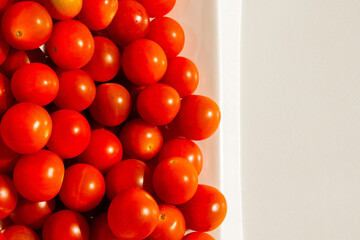 Cherry tomatoes. Cherry tomatoes in a white plate. Hard light. Bright light and shadow.