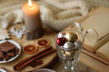 Cup of tea or coffee, various sweets and spices, Christmas decorations, comfy blanket, books and glasses. Selective focus.