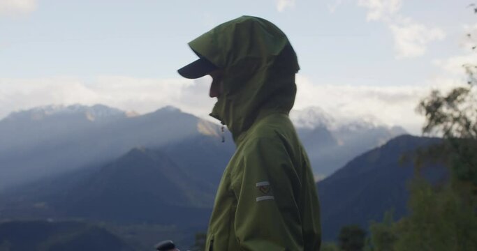Hiker woman in hood looking around in walk in mountain. medium shot